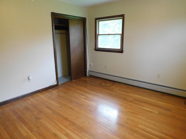 81 S Main St, Athens, ME 04912 - unfurnished bedroom with a baseboard heating unit, light wood-style flooring, a closet, and baseboards