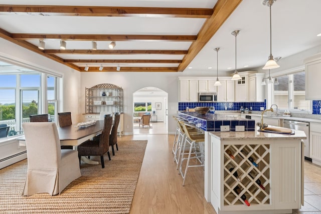 25 Ocean Ave, Cape Elizabeth, ME 04107 - dining area with arched walkways, plenty of natural light, beamed ceiling, and light wood finished floors