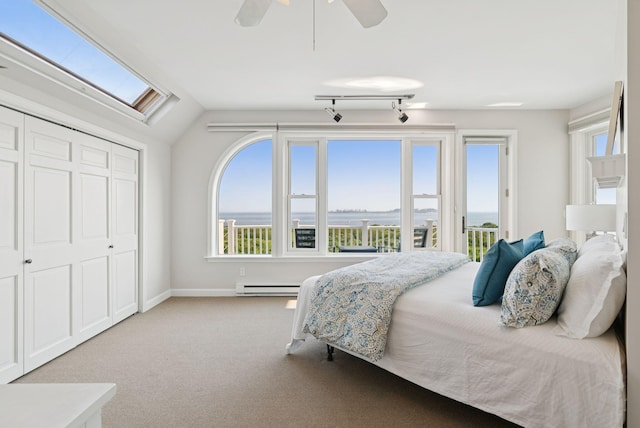 25 Ocean Ave, Cape Elizabeth, ME 04107 - carpeted bedroom with a baseboard heating unit, multiple windows, lofted ceiling, a closet, and access to exterior