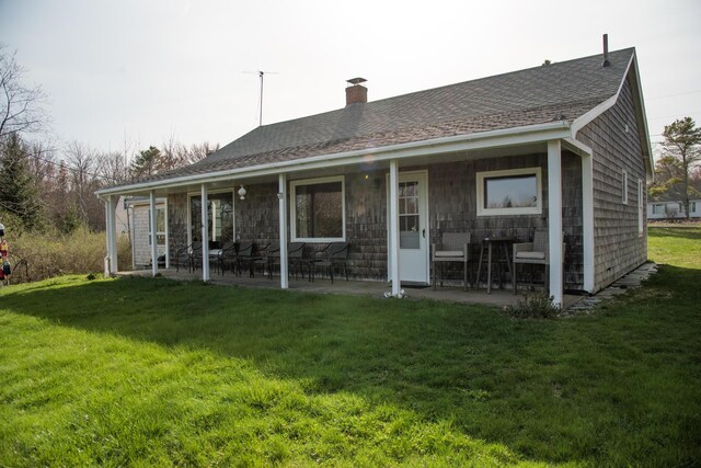 42 Old Mill Rd, Bristol, ME 04554 - back of property with a chimney, a patio area, a lawn, and a shingled roof
