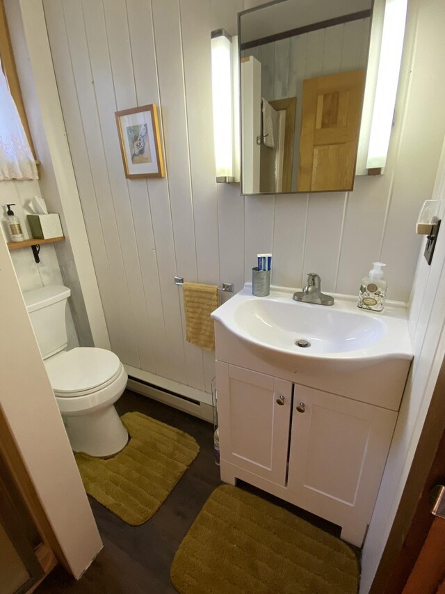 42 Old Mill Rd, Bristol, ME 04554 - half bathroom featuring baseboard heating, vanity, toilet, and wood finished floors