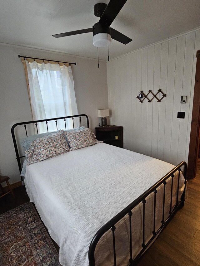 42 Old Mill Rd, Bristol, ME 04554 - bedroom featuring dark wood-style flooring, wood walls, ornamental molding, a ceiling fan, and baseboards