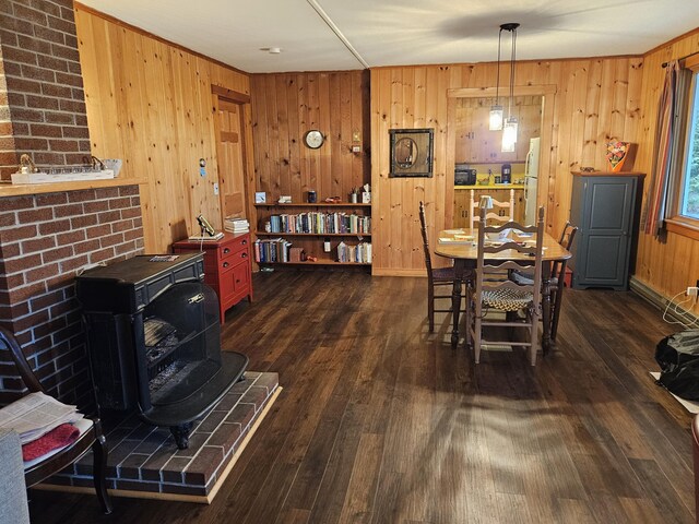 42 Old Mill Rd, Bristol, ME 04554 - dining room with a wood stove, dark wood-style floors, wood walls, and baseboards