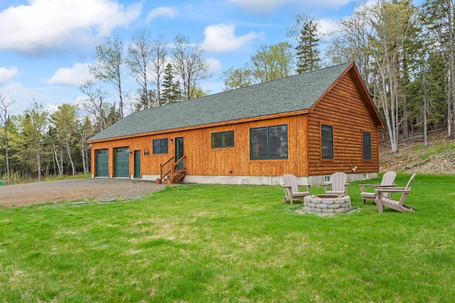 3935 Main St, Rangeley, ME 04970 - view of front of property featuring a shingled roof, an outdoor fire pit, a garage, driveway, and a front yard