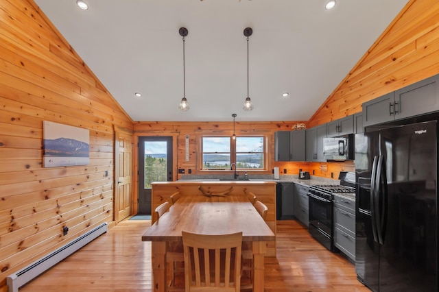 3935 Main St, Rangeley, ME 04970 - kitchen featuring black appliances, a baseboard radiator, butcher block countertops, light wood-style flooring, and wooden walls
