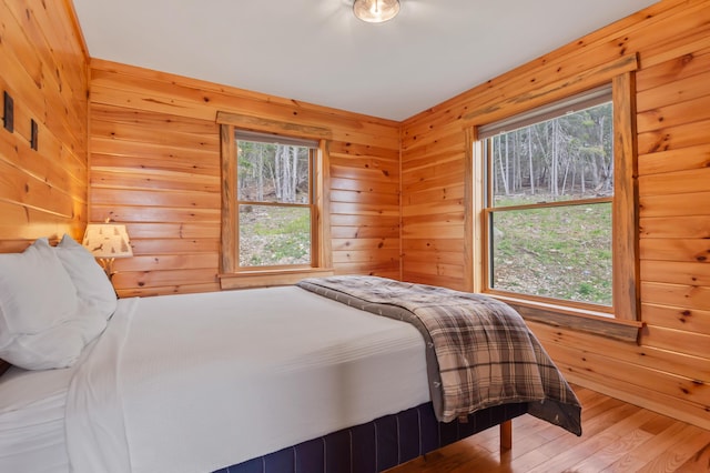 3935 Main St, Rangeley, ME 04970 - bedroom featuring multiple windows, wood finished floors, and wood walls