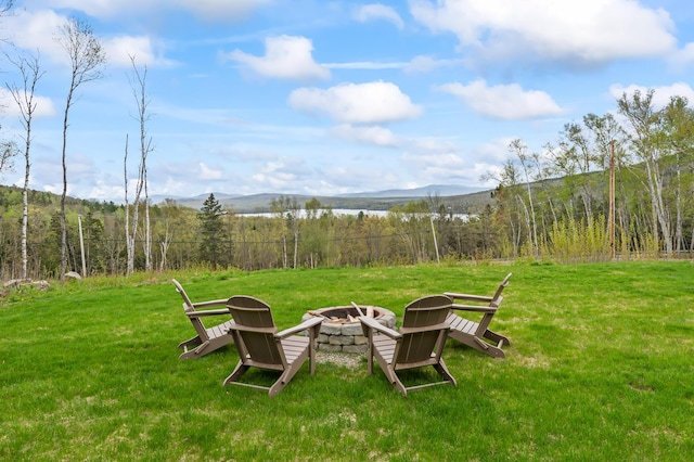 3935 Main St, Rangeley, ME 04970 - view of green lawn featuring an outdoor fire pit, a mountain view, and a wooded view