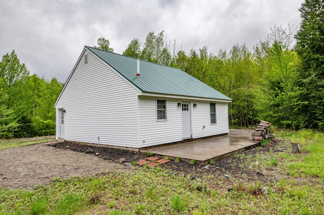 22 Partridge Ln, Medford, ME 04463 - rear view of property featuring metal roof, a wooded view, and a patio area