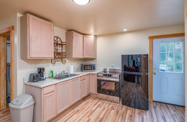 22 Partridge Ln, Medford, ME 04463 - kitchen featuring stainless steel appliances, light brown cabinetry, a sink, light wood-style floors, and light countertops