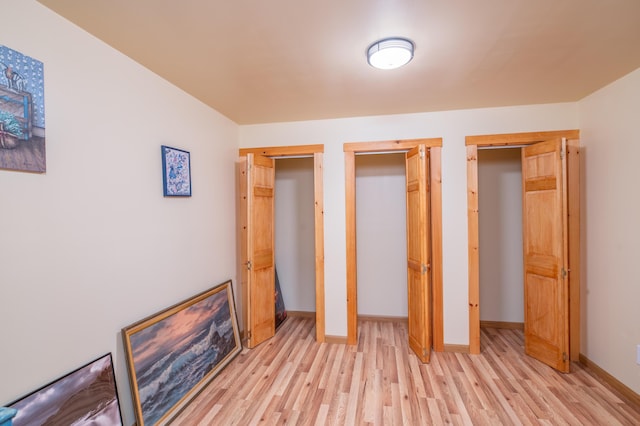 22 Partridge Ln, Medford, ME 04463 - unfurnished bedroom featuring light wood finished floors, two closets, and baseboards