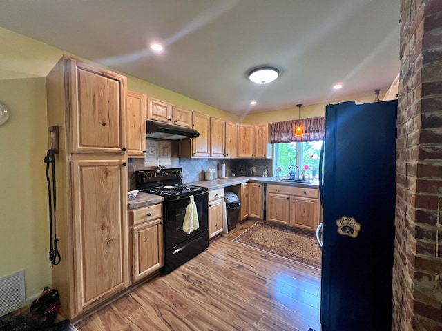 13 Pearl St, Fort Kent, ME 04743 - kitchen with black appliances, under cabinet range hood, light brown cabinetry, wood finished floors, and light countertops