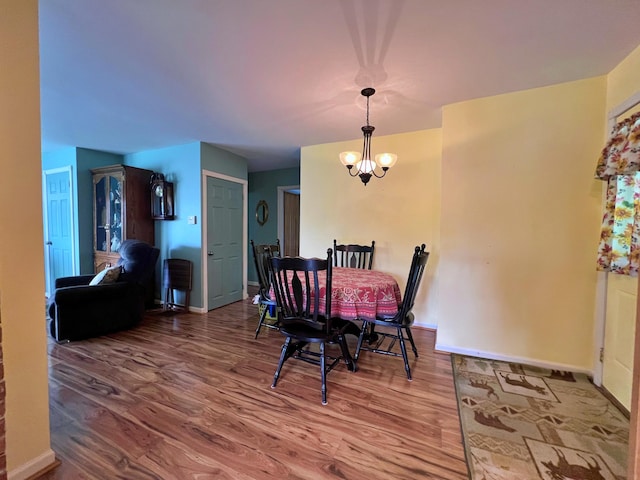 13 Pearl St, Fort Kent, ME 04743 - dining area featuring wood finished floors, a chandelier, and baseboards