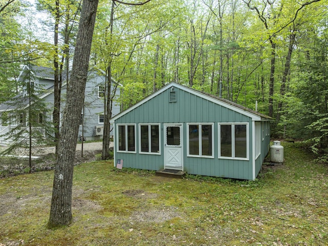 18 Julian St, Sebago, ME 04029 - view of front facade featuring board and batten siding and a wooded view