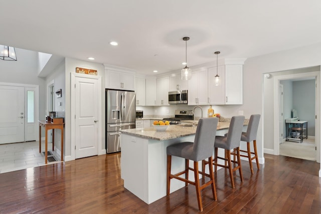 45 S Ridge Rd, Falmouth, ME 04105 - kitchen featuring appliances with stainless steel finishes, a peninsula, light stone countertops, recessed lighting, and white cabinets