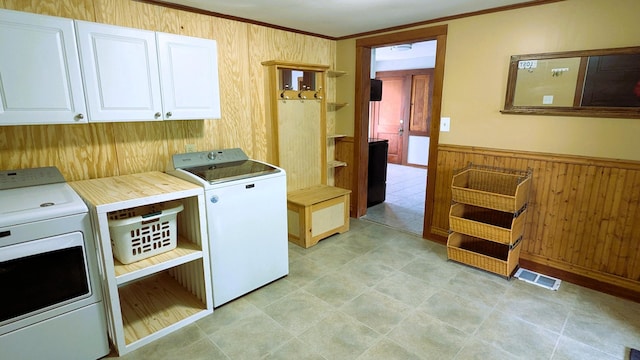 191 Bates St, Pittsfield, ME 04967 - laundry room with cabinet space, separate washer and dryer, wood walls, a wainscoted wall, and ornamental molding