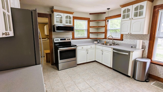 191 Bates St, Pittsfield, ME 04967 - kitchen with stainless steel appliances, tasteful backsplash, white cabinets, glass insert cabinets, and light countertops