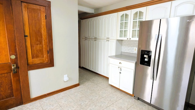 191 Bates St, Pittsfield, ME 04967 - kitchen with stainless steel fridge, glass insert cabinets, backsplash, light countertops, and light tile patterned flooring