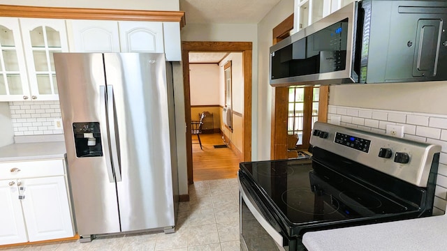 191 Bates St, Pittsfield, ME 04967 - kitchen featuring appliances with stainless steel finishes, tasteful backsplash, glass insert cabinets, white cabinets, and light countertops