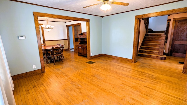 191 Bates St, Pittsfield, ME 04967 - empty room with light wood-style floors, a ceiling fan, ornamental molding, stairs, and a chandelier