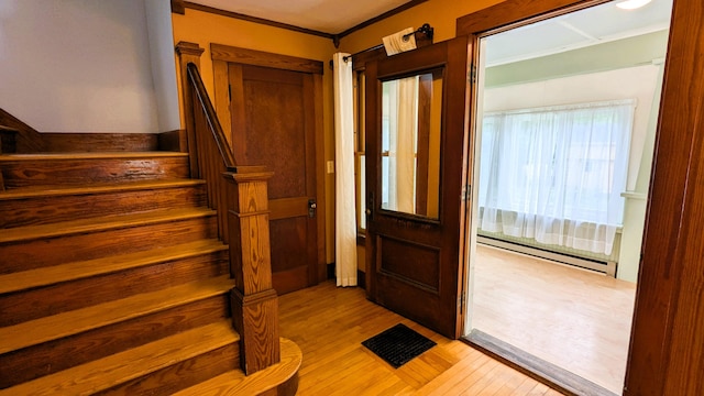 191 Bates St, Pittsfield, ME 04967 - foyer featuring a baseboard radiator, light wood-style flooring, stairway, and crown molding