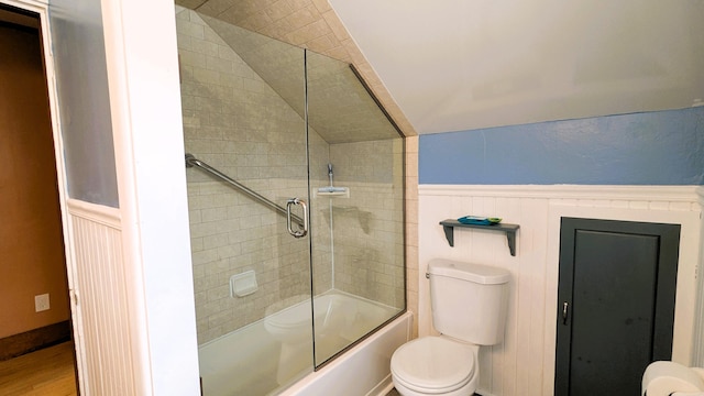 191 Bates St, Pittsfield, ME 04967 - full bath with a wainscoted wall, vaulted ceiling, combined bath / shower with glass door, a decorative wall, and wood finished floors