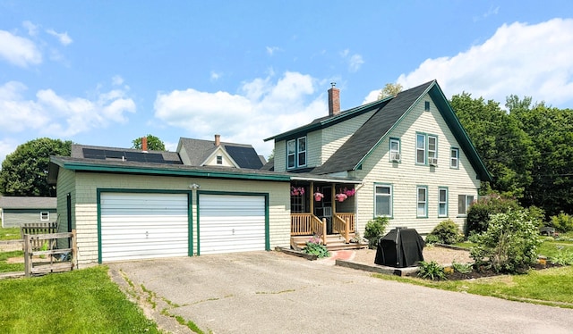191 Bates St, Pittsfield, ME 04967 - view of front of property with a garage, asphalt driveway, solar panels, a chimney, and roof with shingles