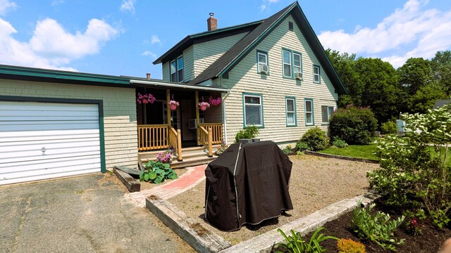 191 Bates St, Pittsfield, ME 04967 - view of front facade featuring a garage, a chimney, and covered porch