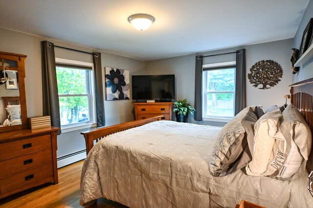 77 Carter St, Portland, ME 04103 - bedroom featuring baseboard heating, multiple windows, and wood finished floors