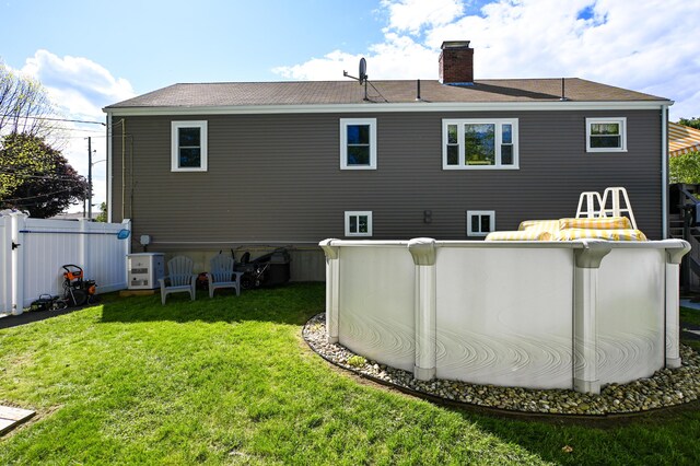 77 Carter St, Portland, ME 04103 - back of house featuring a chimney, roof with shingles, and an outdoor pool