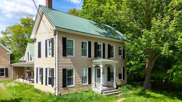 26 Unity Rd, Albion, ME 04910 - colonial house with a chimney, metal roof, and a front lawn