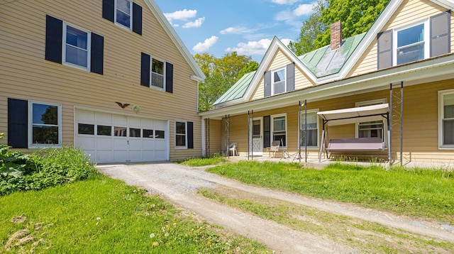 26 Unity Rd, Albion, ME 04910 - view of front facade featuring an attached garage, a porch, dirt driveway, and a chimney