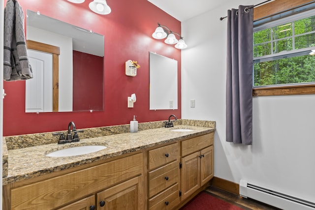 2 Ball Park Rd, Lewiston, ME 04240 - bathroom featuring a baseboard radiator, double vanity, and baseboards
