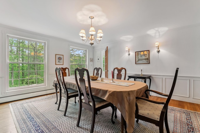 3 Payneton Hill Rd, York, ME 03909 - dining area with a chandelier, a decorative wall, light wood-style floors, a wainscoted wall, and a baseboard radiator