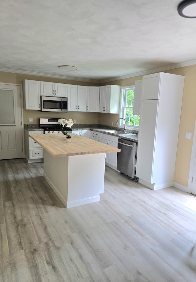 60 Rolling Rdg, Jay, ME 04239 - kitchen with butcher block countertops, stainless steel appliances, a sink, crown molding, and light wood-type flooring