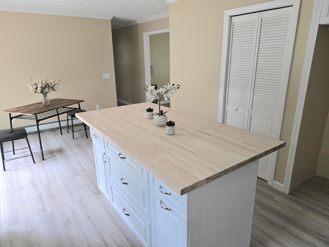 60 Rolling Rdg, Jay, ME 04239 - kitchen with butcher block counters, light wood finished floors, white cabinets, a kitchen island, and crown molding