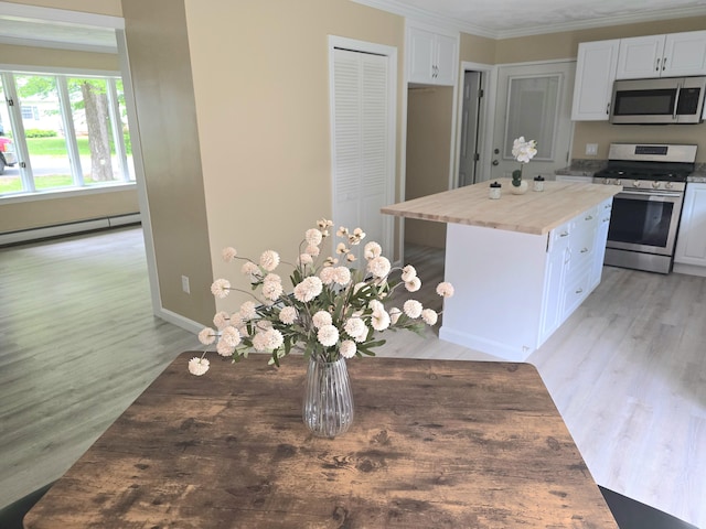60 Rolling Rdg, Jay, ME 04239 - kitchen featuring appliances with stainless steel finishes, light wood finished floors, white cabinets, a baseboard heating unit, and ornamental molding