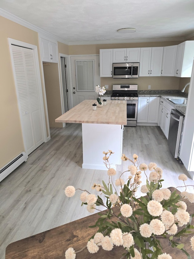 60 Rolling Rdg, Jay, ME 04239 - kitchen featuring stainless steel appliances, butcher block countertops, a sink, ornamental molding, and a kitchen island
