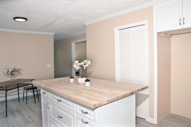 60 Rolling Rdg, Jay, ME 04239 - kitchen with light wood finished floors, butcher block counters, white cabinets, a kitchen island, and ornamental molding