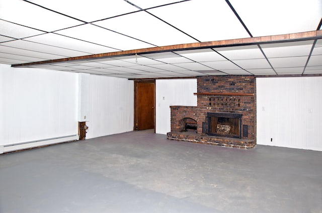 60 Rolling Rdg, Jay, ME 04239 - unfurnished living room with concrete flooring, a baseboard heating unit, a fireplace, and wood walls