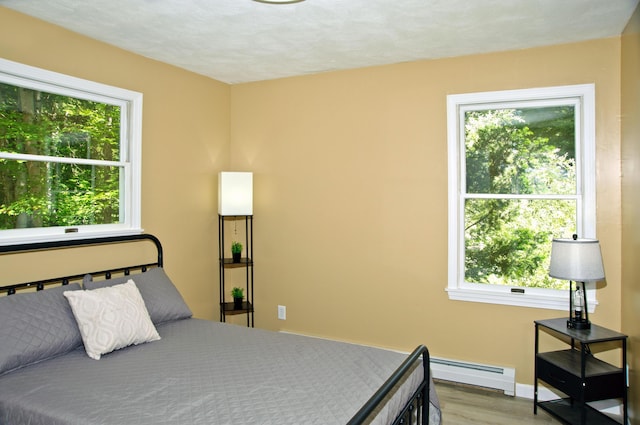60 Rolling Rdg, Jay, ME 04239 - bedroom featuring a baseboard radiator, multiple windows, and wood finished floors