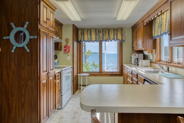 16 Tilton Ln, Southport, ME 04576 - kitchen featuring white electric stove, light countertops, a sink, light flooring, and brown cabinetry