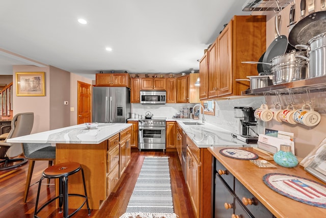 27 Wilmer Chase Rd, North Berwick, ME 03906 - kitchen with appliances with stainless steel finishes, dark wood-style flooring, a sink, decorative backsplash, and a breakfast bar