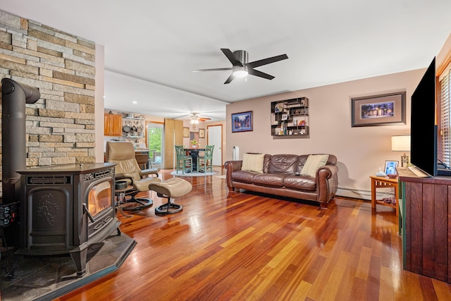 27 Wilmer Chase Rd, North Berwick, ME 03906 - living room featuring a wood stove, ceiling fan, wood finished floors, and baseboard heating