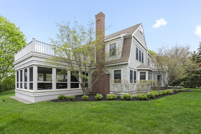 52 Lester B Orcutt Blvd, Biddeford, ME 04006 - back of property with a yard, a chimney, roof with shingles, and a sunroom
