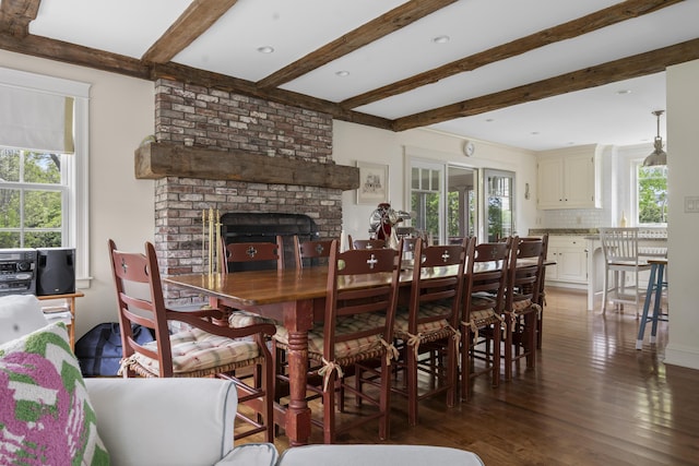 52 Lester B Orcutt Blvd, Biddeford, ME 04006 - dining space with healthy amount of natural light, wood finished floors, beamed ceiling, and a brick fireplace