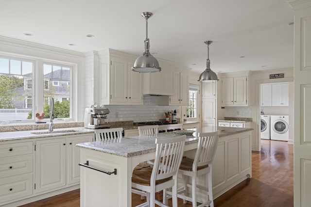 52 Lester B Orcutt Blvd, Biddeford, ME 04006 - kitchen with a sink, washing machine and clothes dryer, decorative backsplash, a kitchen island, and healthy amount of natural light