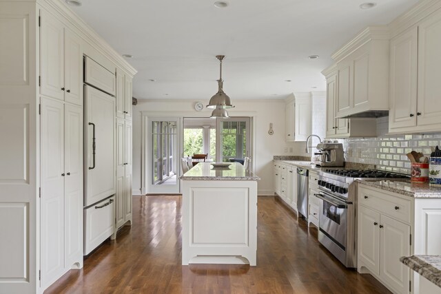 52 Lester B Orcutt Blvd, Biddeford, ME 04006 - kitchen featuring high end appliances, a kitchen island, decorative backsplash, dark wood-style flooring, and light stone counters