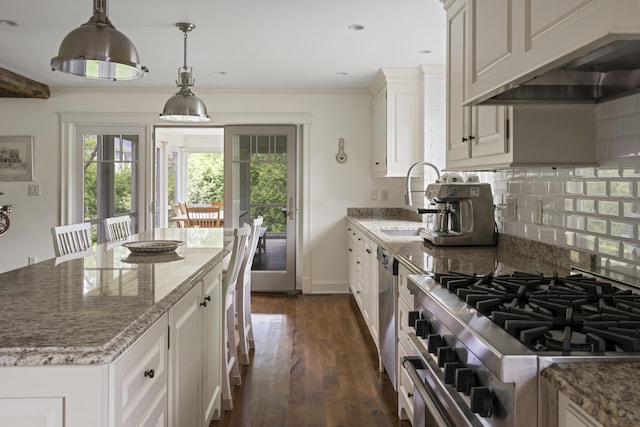 52 Lester B Orcutt Blvd, Biddeford, ME 04006 - kitchen with range hood, backsplash, light stone counters, white cabinets, and dark wood-type flooring