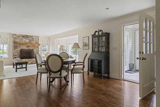 52 Lester B Orcutt Blvd, Biddeford, ME 04006 - dining space featuring a stone fireplace, dark wood finished floors, ornamental molding, and baseboards