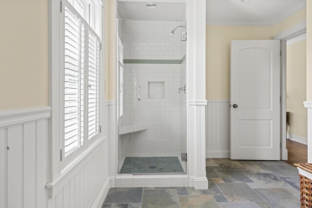 52 Lester B Orcutt Blvd, Biddeford, ME 04006 - bathroom featuring a shower stall, stone finish flooring, a wainscoted wall, crown molding, and a decorative wall